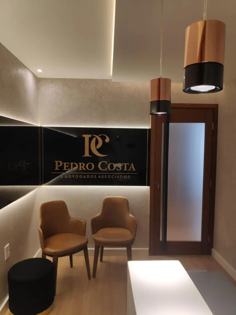 Recepção com poltronas e a placa de vidro preto
